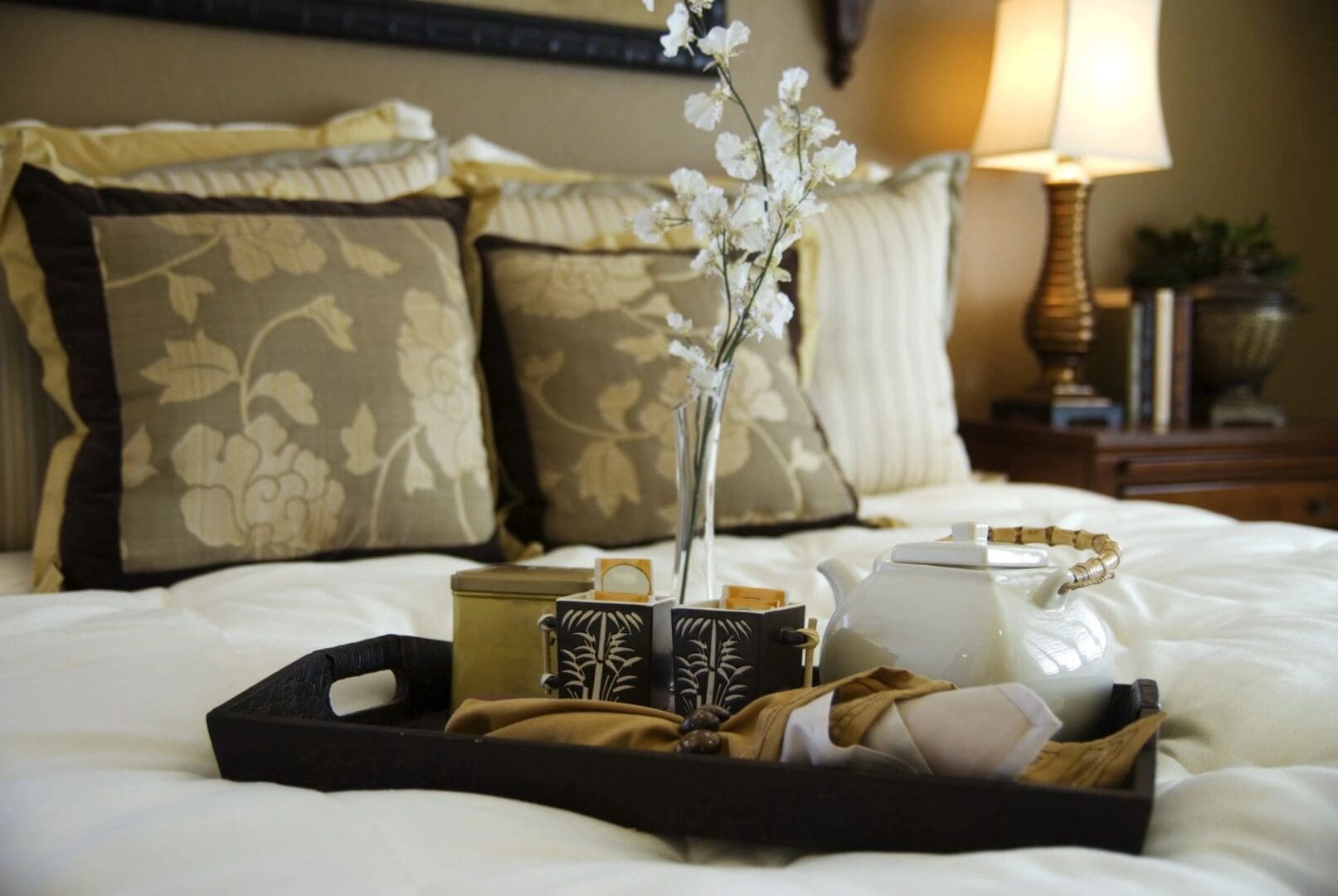 A tray with flowers and tissue on top of the bed.