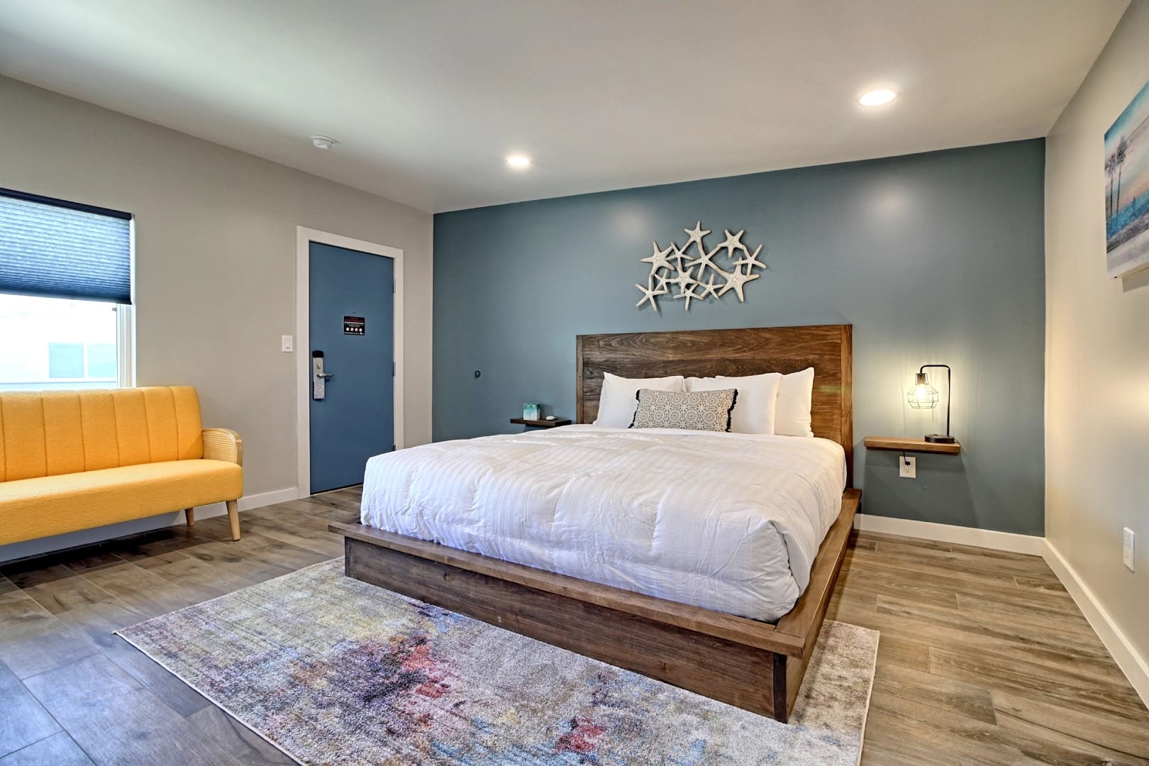 A bedroom with a bed, chair and blue walls.